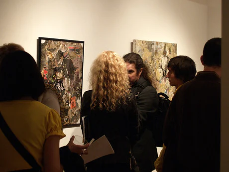 Visitors gathering in front of works at an exhibition